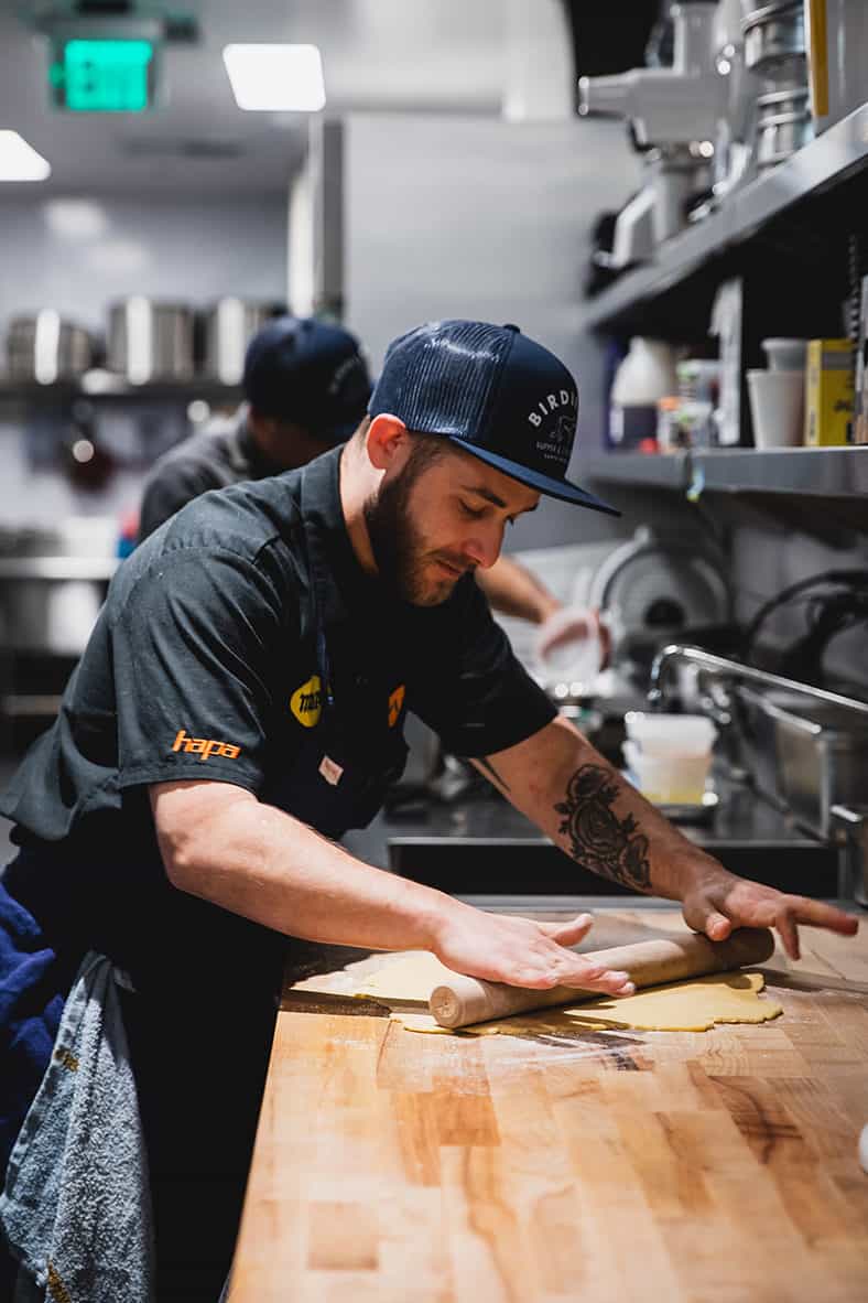 Chef De Cuisine Matthew Schaler rolling out dough