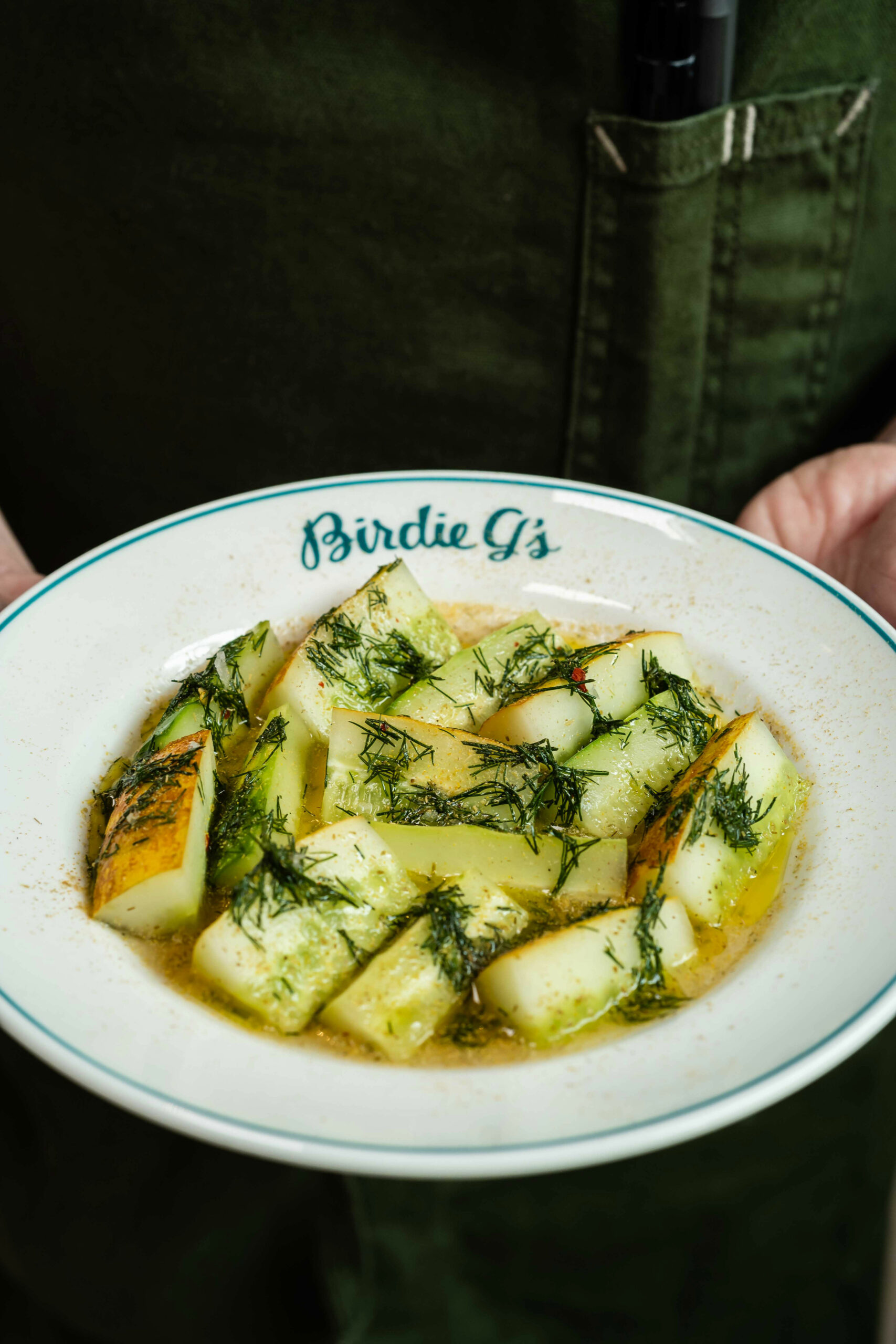 Chef holding a plate of heirloom cucumbers