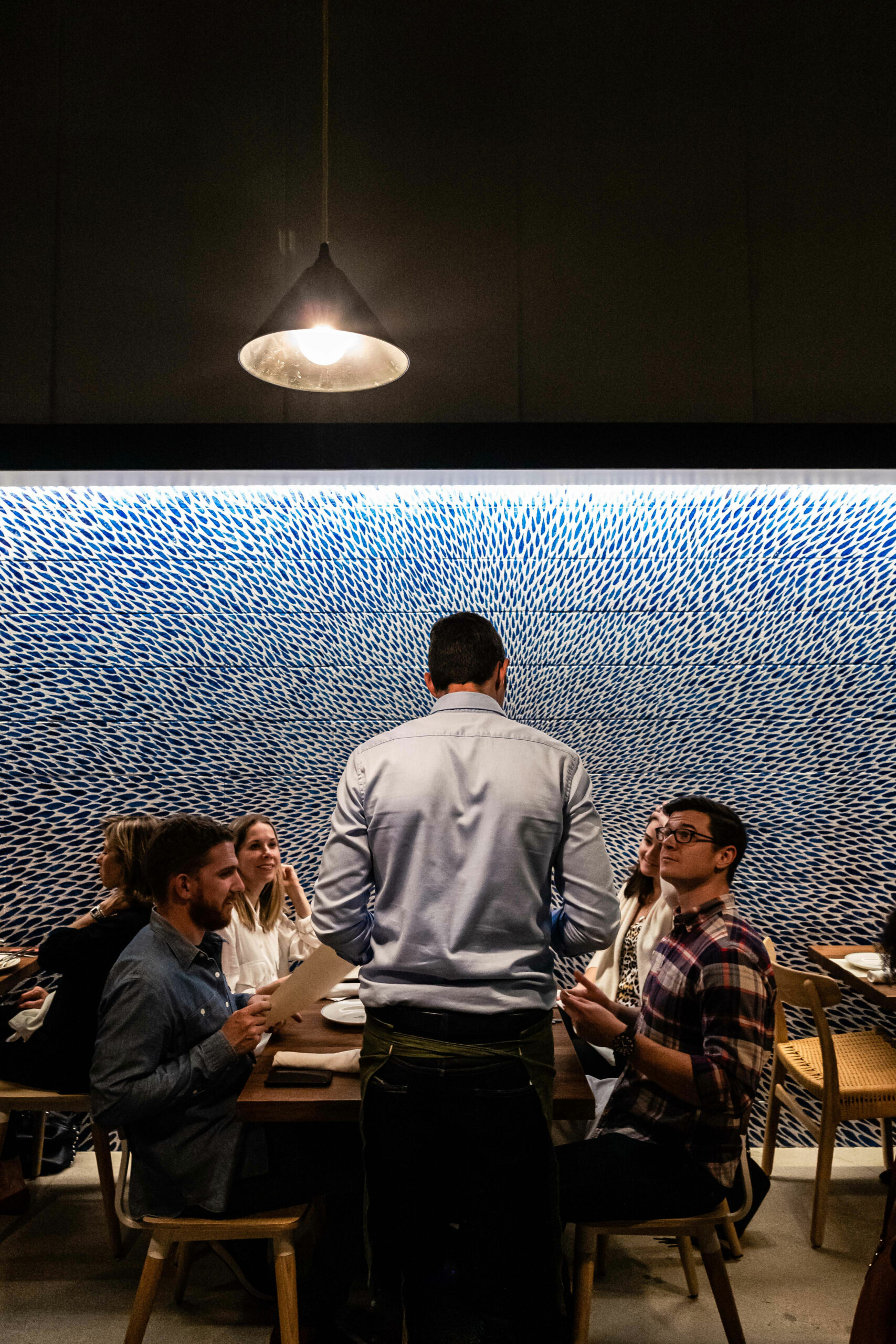 Diners Sitting Near Blue Wall Mural